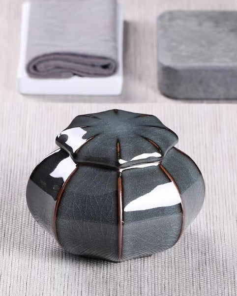 Melon-lobed pumpkin shape ceramic jar with raised reddish-brown rib lines outlining each petal contour