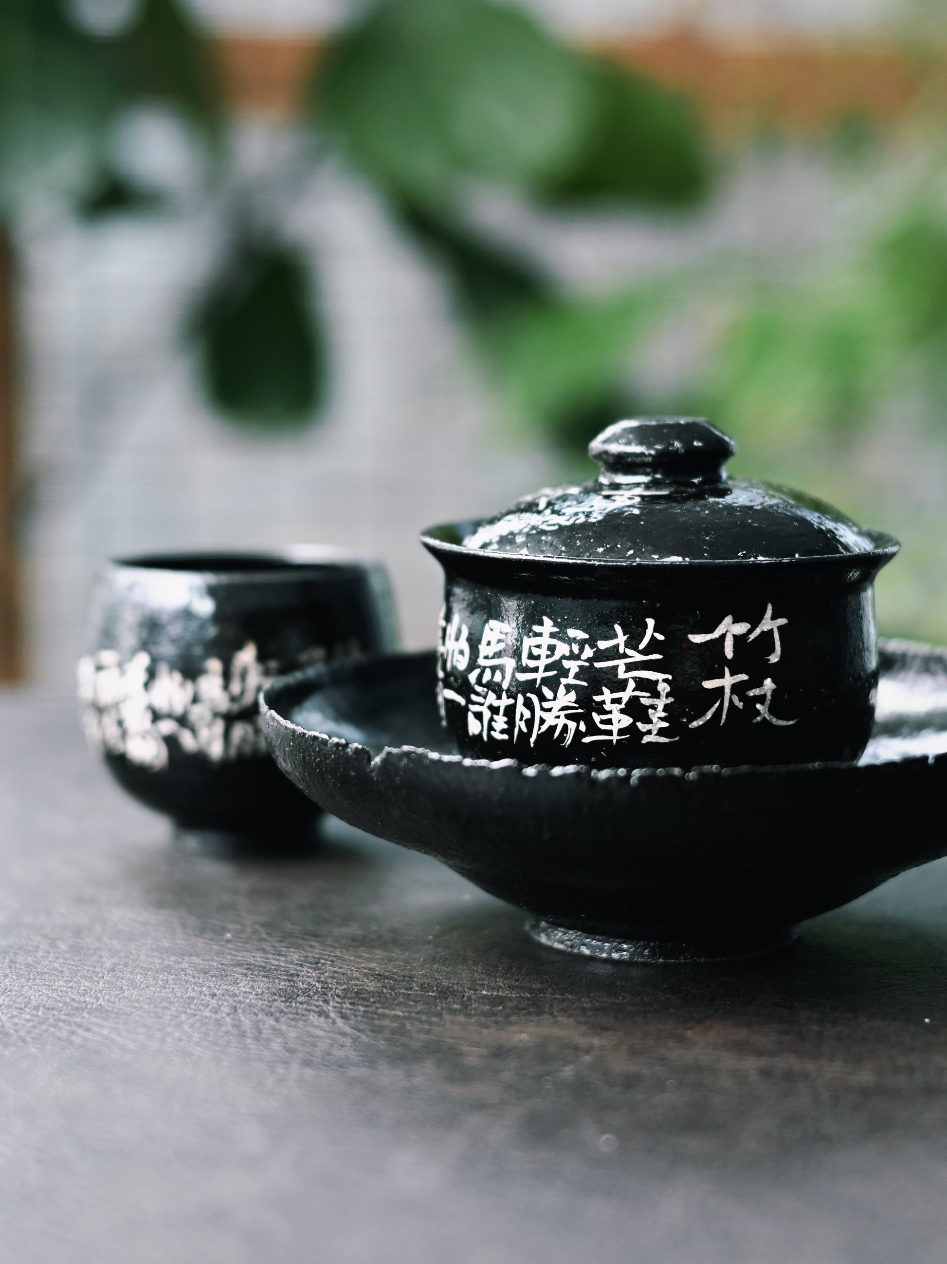 Wabi-sabi style tea set with glossy black glaze, hand-painted silver calligraphy and pine tree design