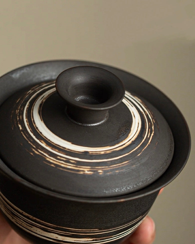 Minimalist tea ceremony gaiwan with rustic slip coating, embodying Zen simplicity and natural materials