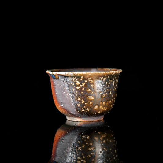 Wood-fired unglazed teacup with natural ash glaze and coffee-brown mottled texture