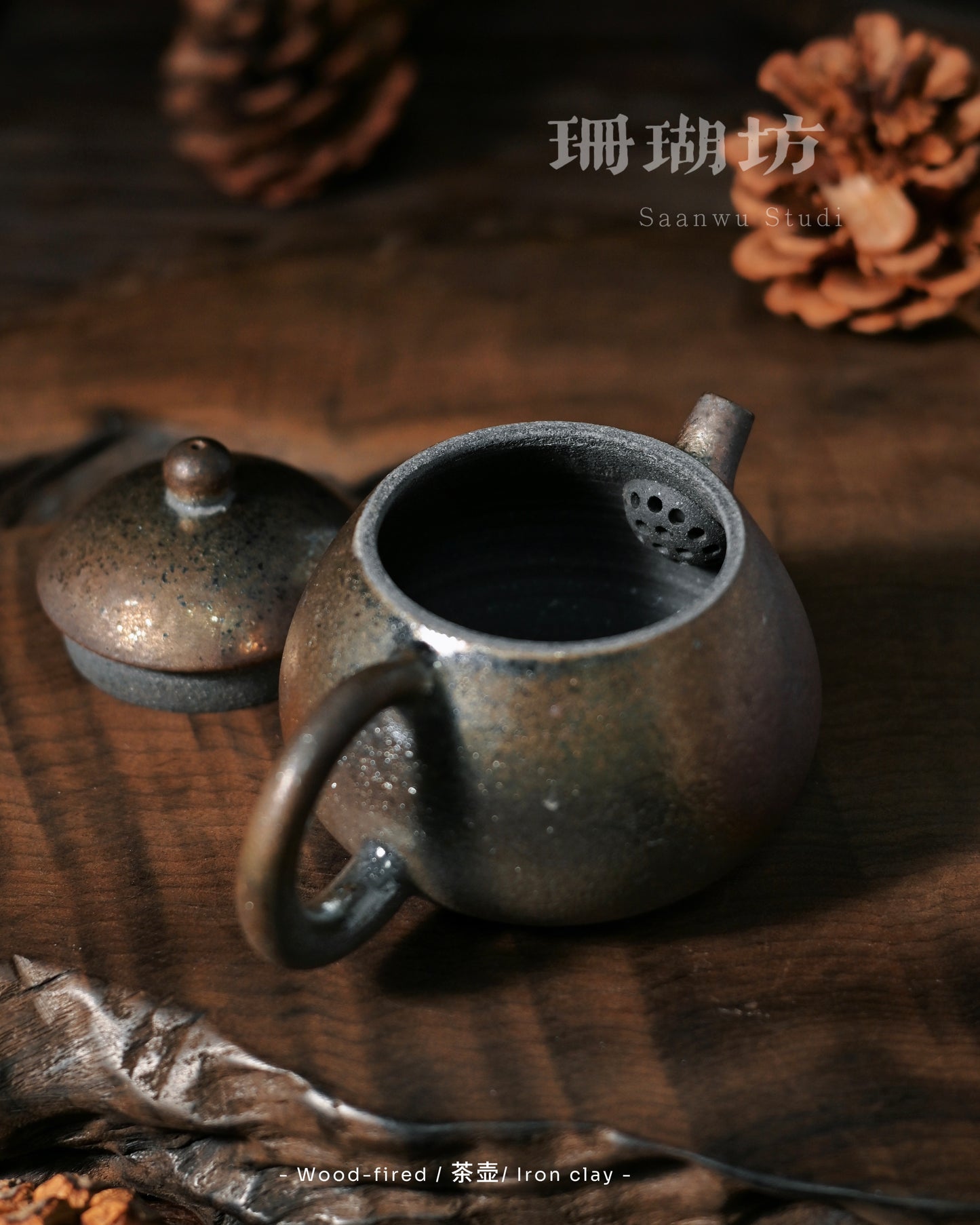 Naked-fired teapot showing flame-path textures and heavy ash accumulation on iron body