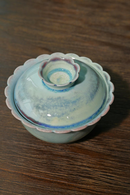 Traditional Chinese wood-fired foliate gaiwan set against dark reflective background