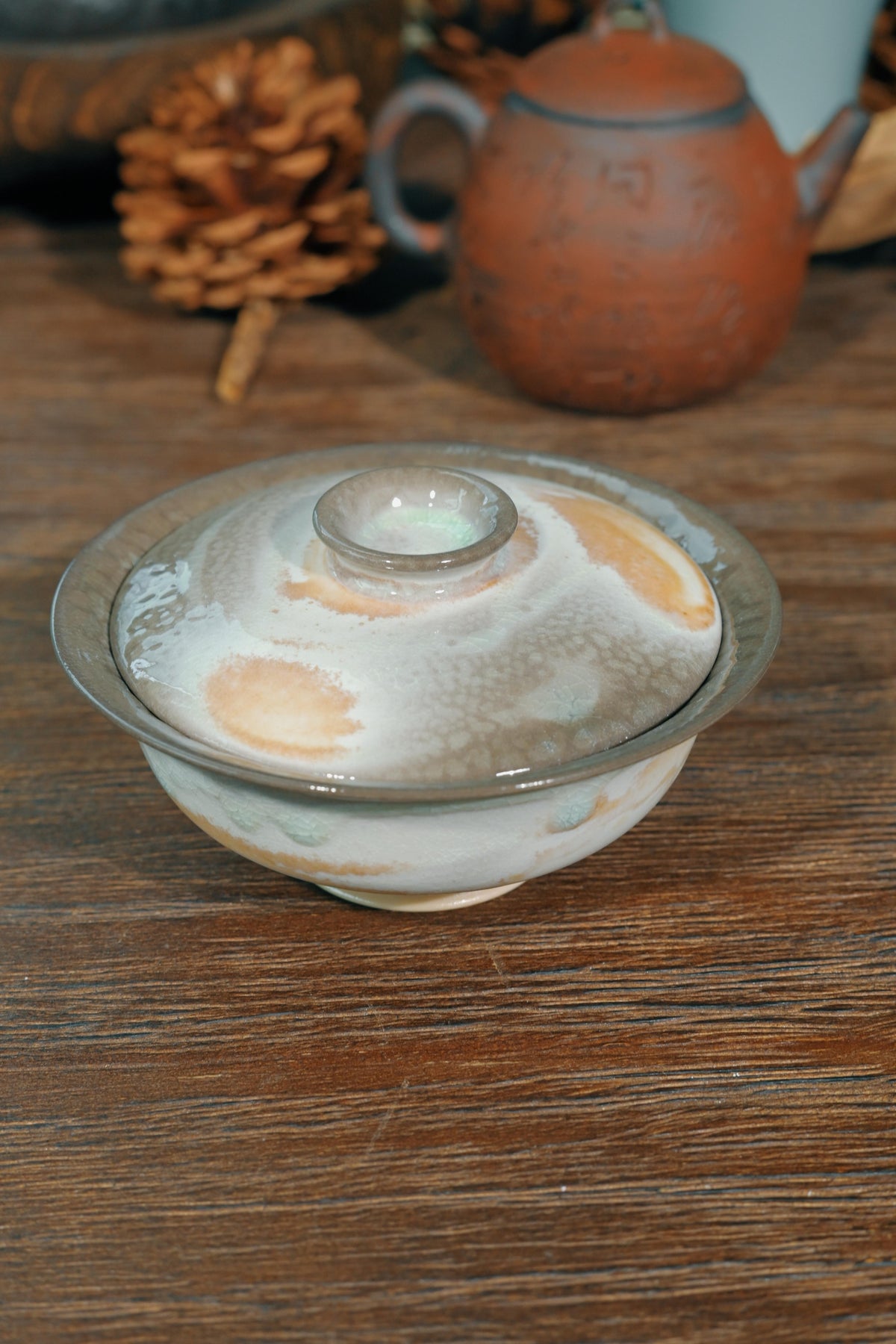 Traditional Chinese wood-fired ingot-shaped gaiwan set against dark reflective background for Gongfu tea