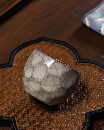 Irregular ceramic cup where flat planes meet at crisp edges creating crystalline appearance