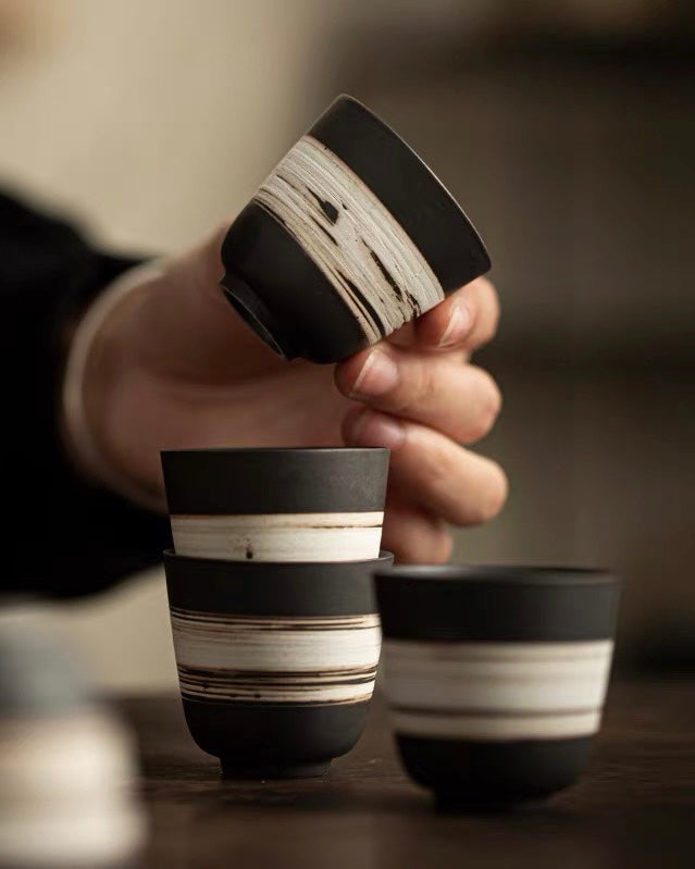 Hand-thrown tea cup with primitive slipware finish, connecting tea drinking to earth elements and tradition