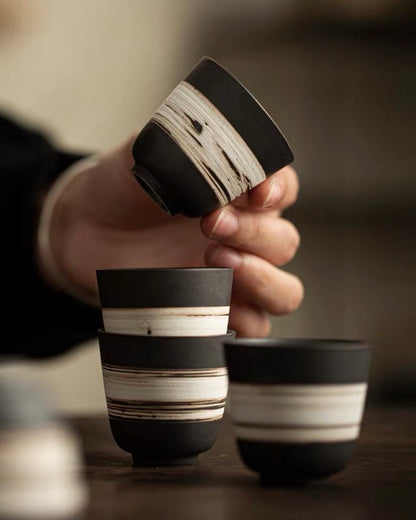 Hand-thrown tea cup with primitive slipware finish, connecting tea drinking to earth elements and tradition