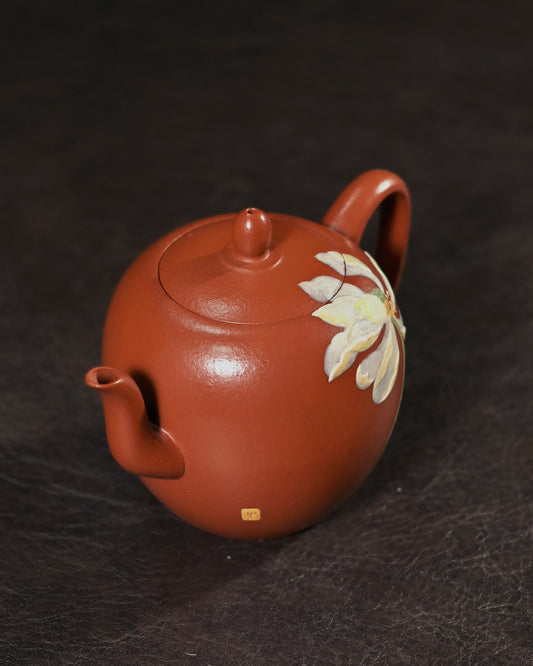 Red-brown Da Hong Pao clay teapot with hand-painted lotus appearing in subtle relief on side body