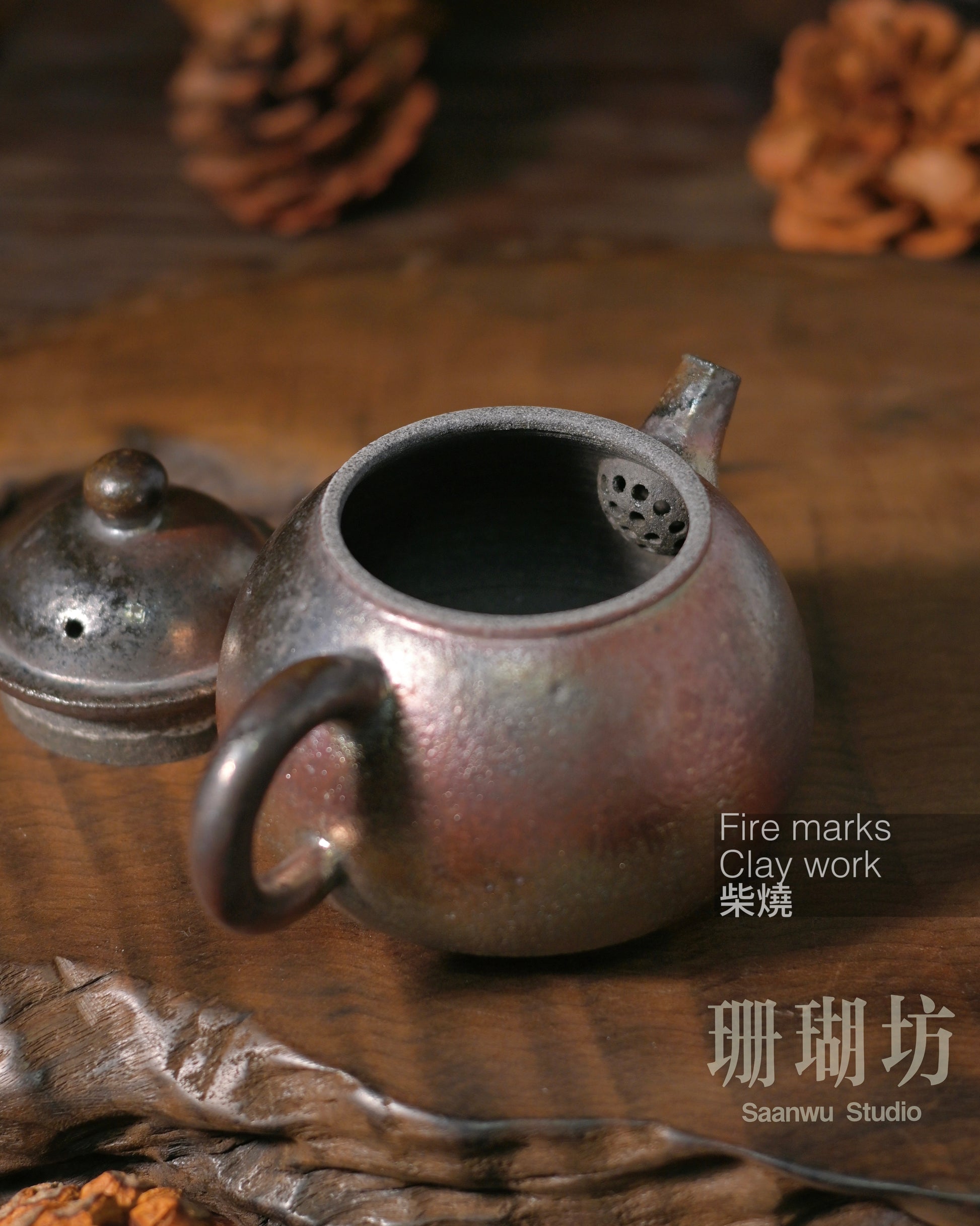 Pear-shaped ceramic teapot with rustic iron clay surface from wood firing