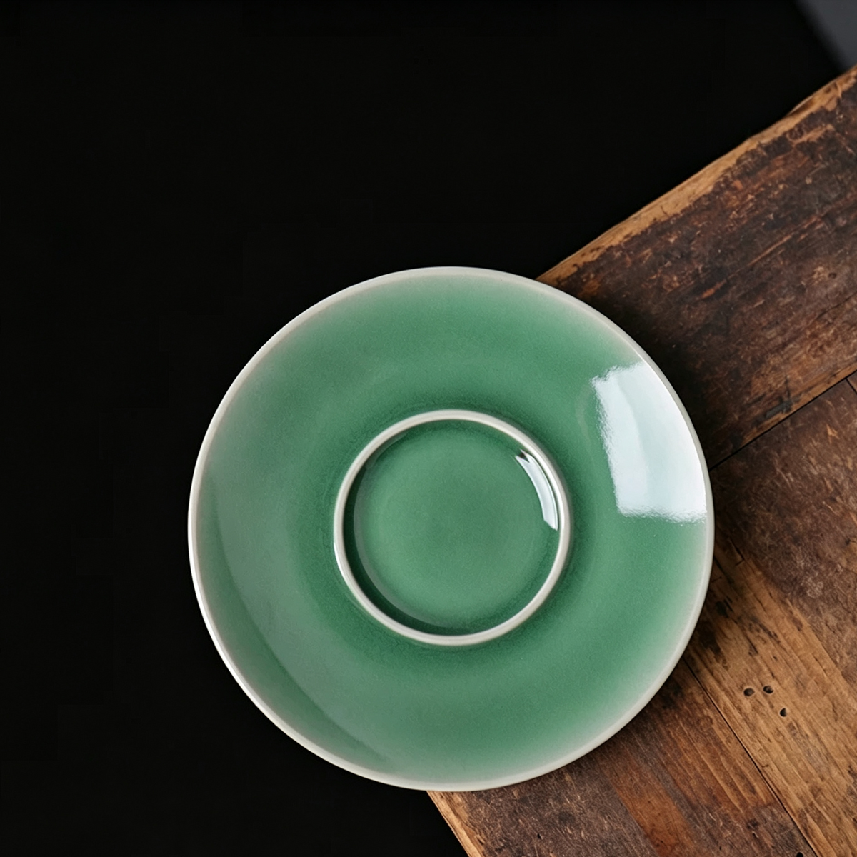 Unique jade-soft Longquan celadon tea bowl with white-line rim highlights on vintage wooden desk