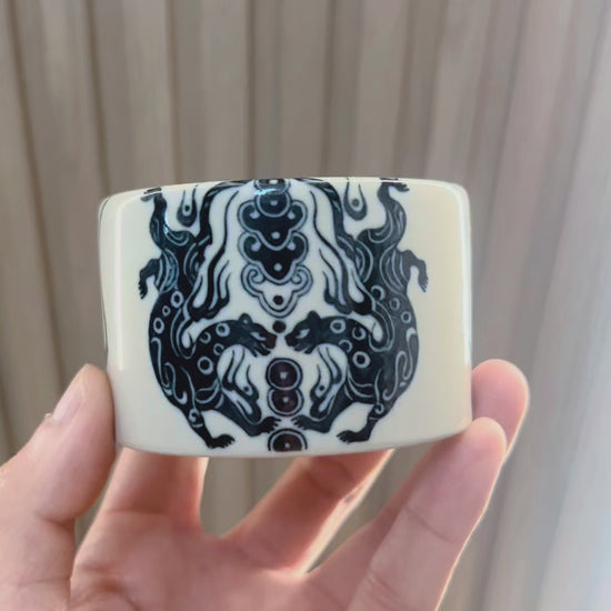 Taoist elements integrated into ceramic 
 teacup design reflecting ancient charm-writing practices