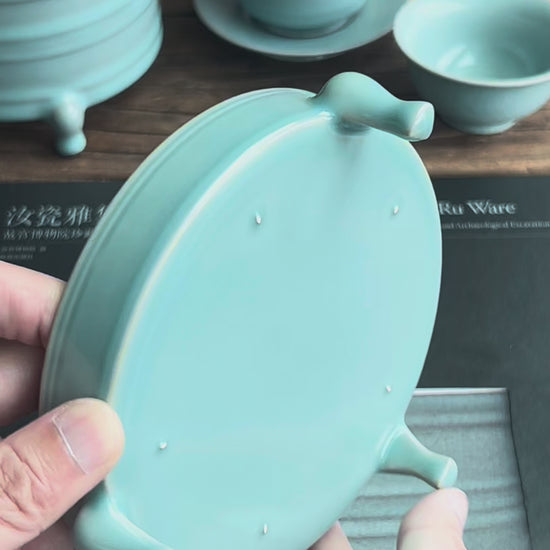 Triple-legged Ru ware celadon stand reproducing Song Dynasty original, featuring crackle-free glaze, five pin marks, and versatile ceremonial use.