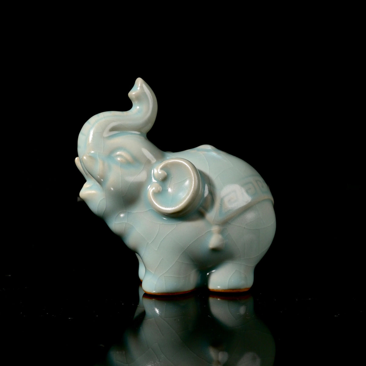 Ru Ware sky-blue glazed auspicious elephant tea pet figurine resting on reflective dark surface