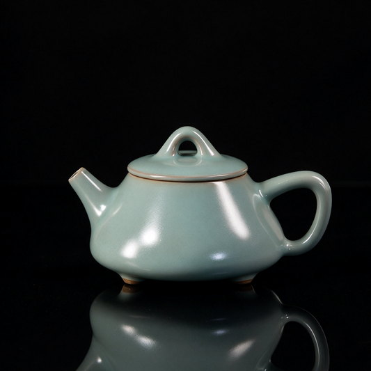 Ru Ware sky-blue glazed three-legged Shipiao teapot resting on rustic brown woven mat