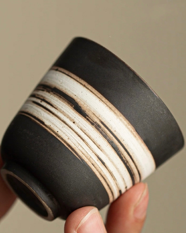 Organic clay tea cup with irregular form and tactile surface, embracing imperfect beauty in tea rituals