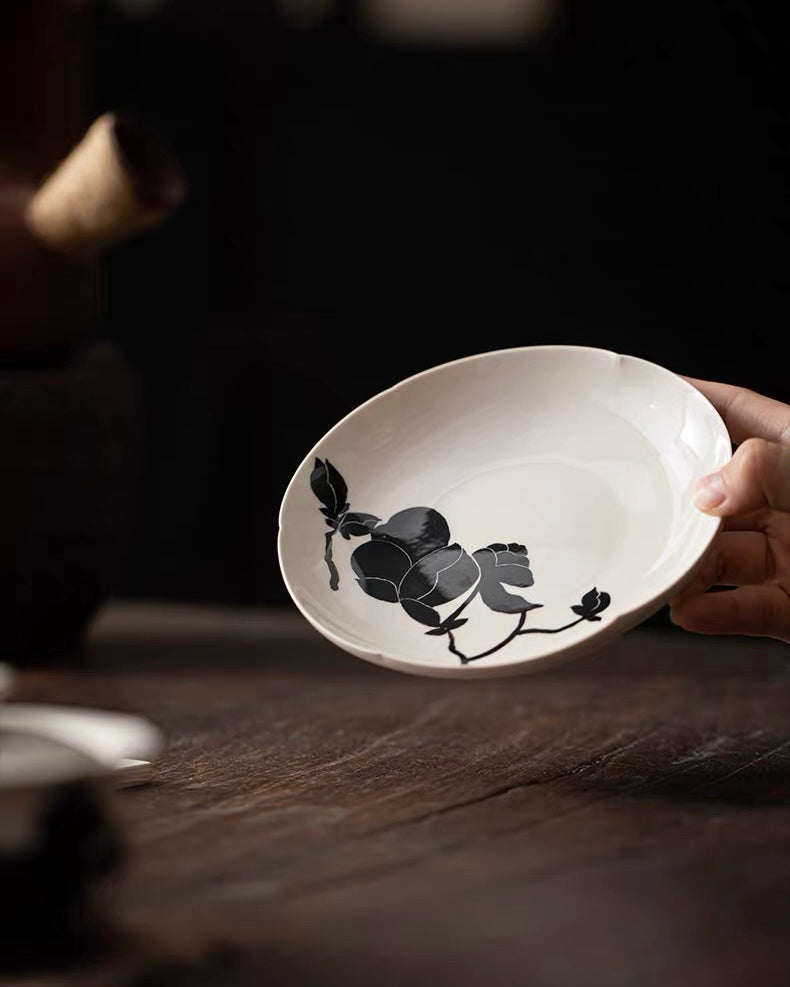 Flower-rim tea tray with jet-black magnolia pattern, provides elegant foundation for tea brewing