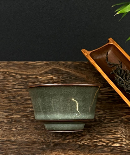 Teacup made from iron-rich clay, finished with luminous celadon glaze and natural cracking.