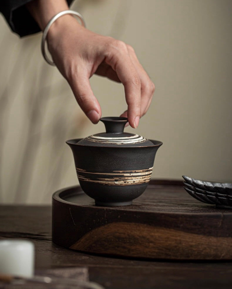 Unadorned tea utensils with raw clay surface, focusing on the essence of tea rather than decoration