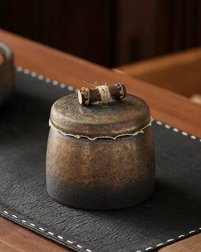 Artistic Chinese tea caddy made of fine stoneware with a golden relief design.