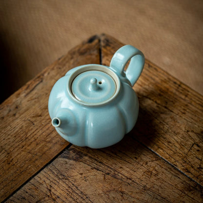 Close-up of natural melon ridges and smooth sky-blue glaze on handcrafted Ru Ware pumpkin teapot