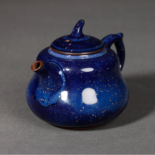 Side profile of Jun kiln deep blue teapot with elegant curved finial and ergonomic handle