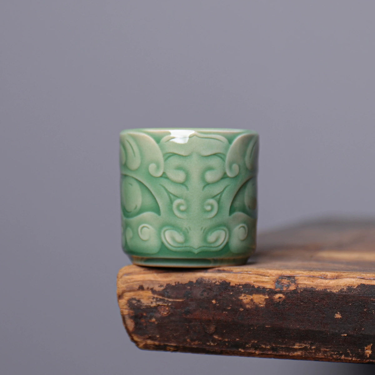 Side profile of Longquan Celadon straight cylinder teacup featuring detailed archaic Taotie motif