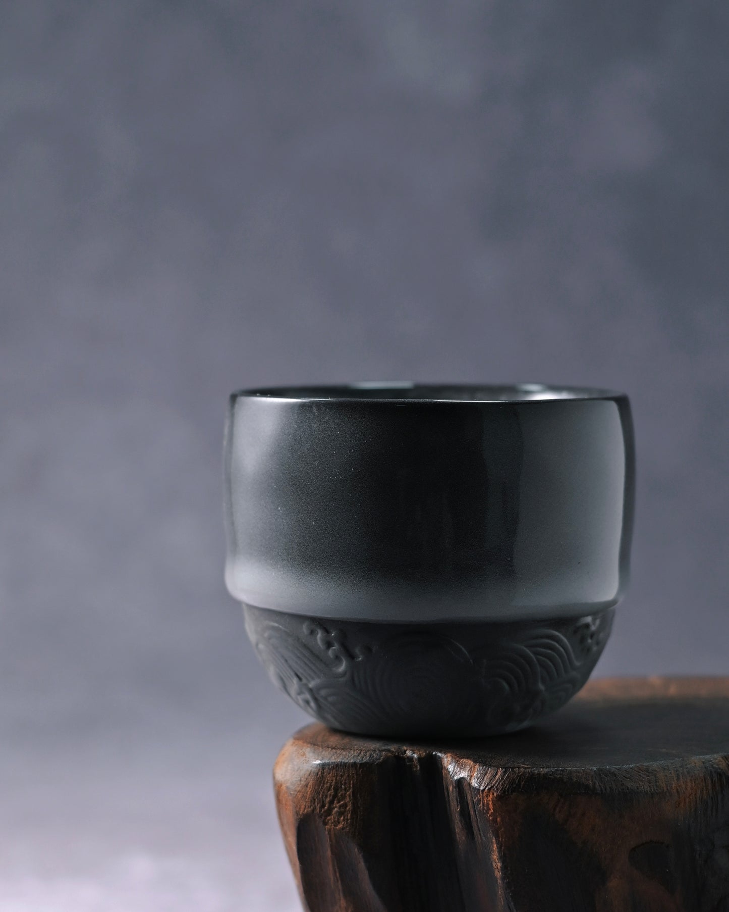 Unglazed lower section revealing natural iron-rich clay texture with incised wave design