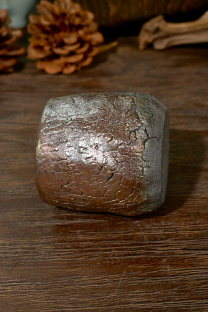 Top-down view of wood-fired teacup interior showing smooth dark iron-rich clay body