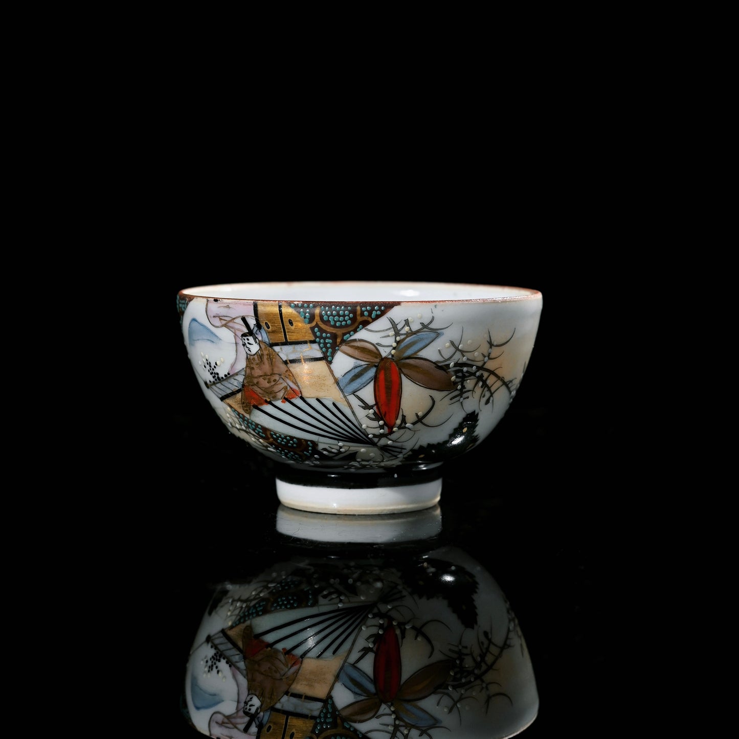 Full set of vintage Japanese Kutani ware tea cups arranged together, showing varied hand-painted motifs in Kinrande style