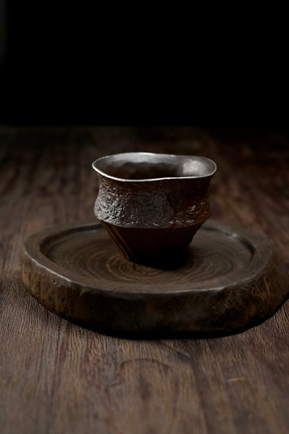 Hand-shaped rustic tea rinsing bowl made from natural coarse clay with earthy tones and tactile surface