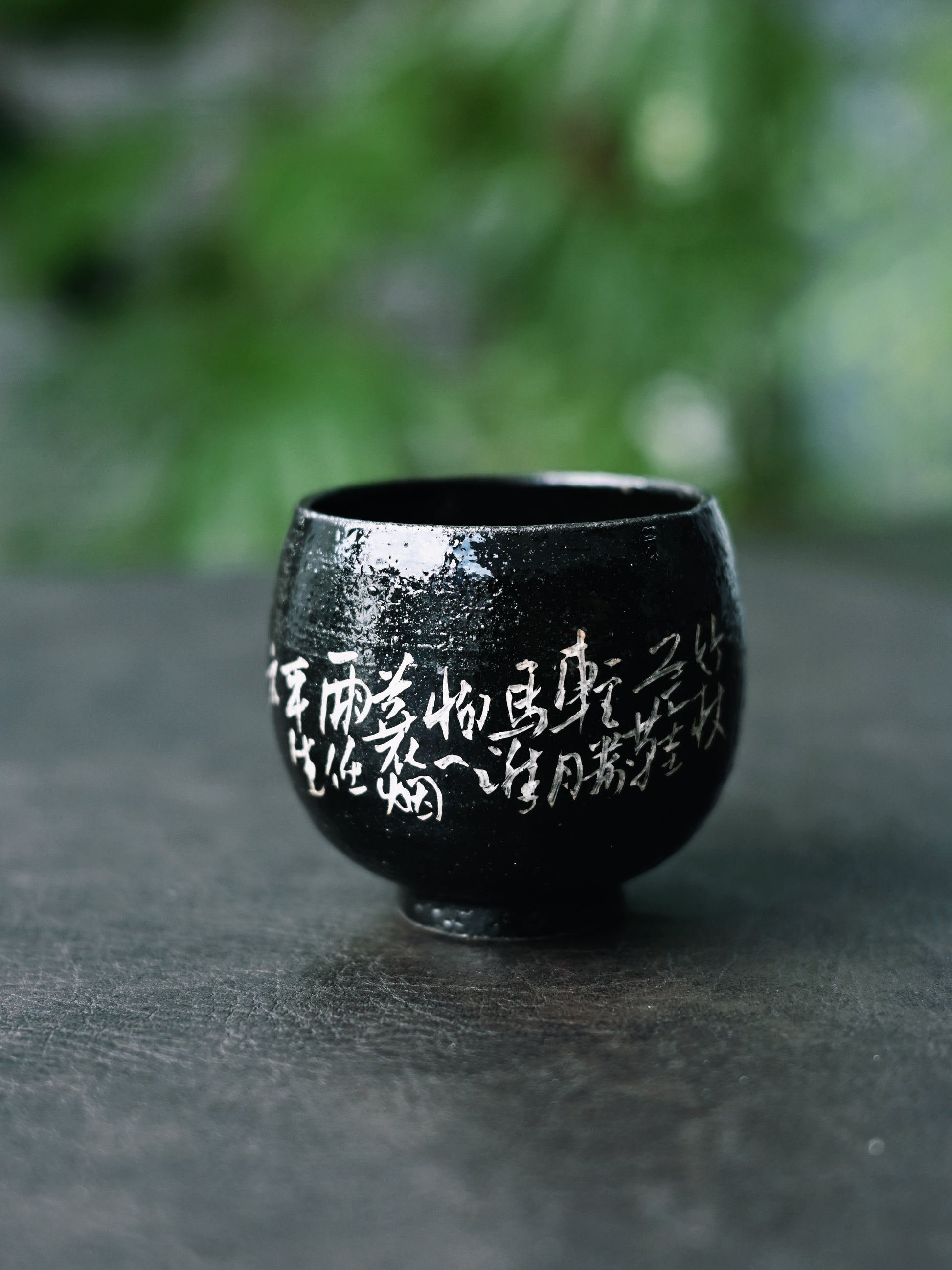 Saanwu Wabi-sabi teacup with shiny black glaze and delicate silver calligraphy design