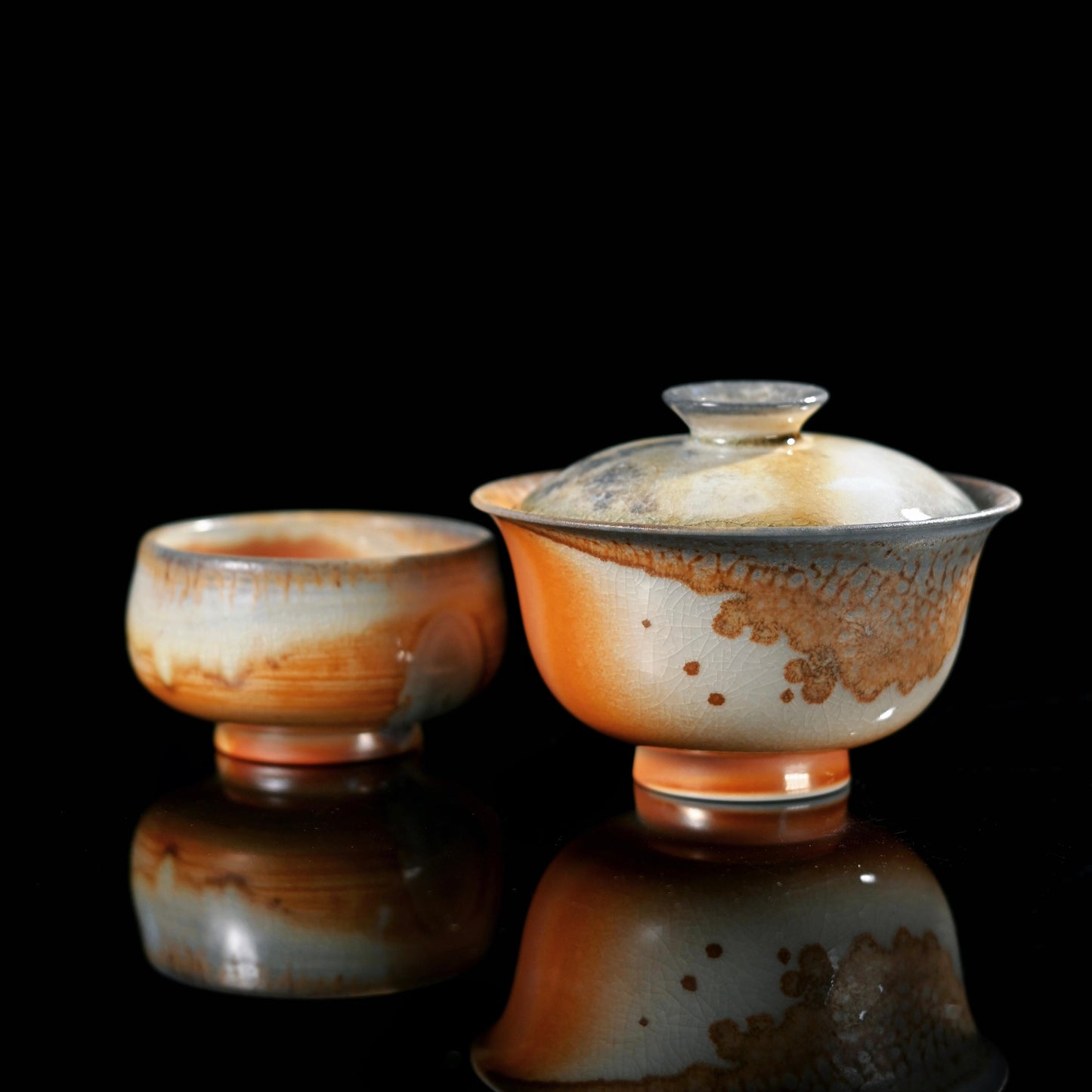 Wood-fired ash glazed lidded bowl and cup set crafted through traditional naked firing technique