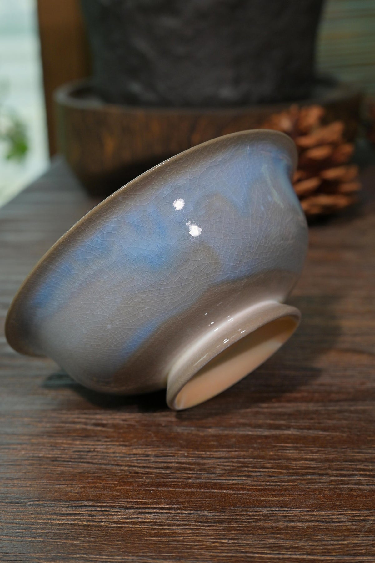 Traditional Chinese wood-fired ingot gaiwan with intense cobalt and crimson glaze set against dark background