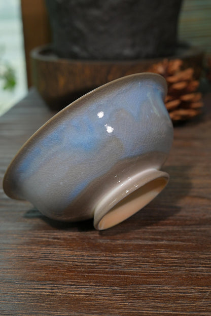 Traditional Chinese wood-fired ingot gaiwan with intense cobalt and crimson glaze set against dark background