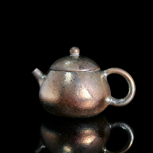 Wood-fired iron-clay pear-shaped teapot with red-gold ash glaze and pronounced fire marks