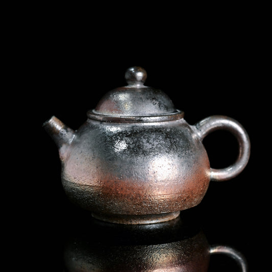 Wood-fired pear-shaped ceramic teapot made from iron clay with natural flame marks