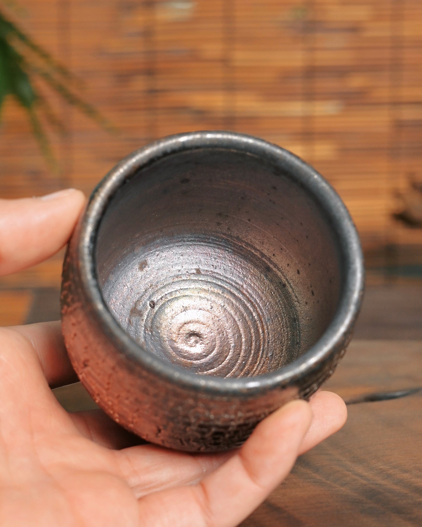 Natural golden-red fire marks from wood kiln firing on unglazed teacup