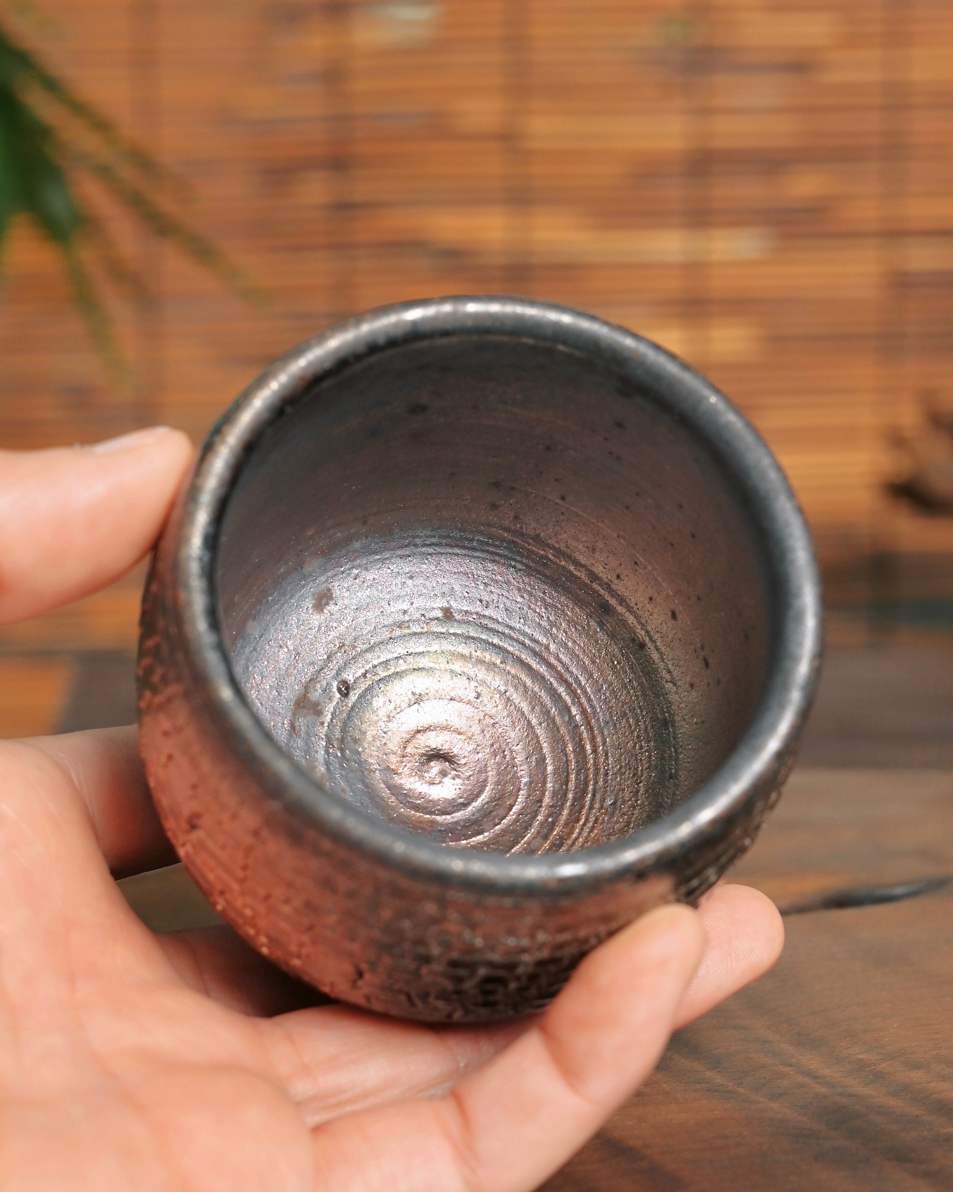 Natural golden-red fire marks from wood kiln firing on unglazed teacup