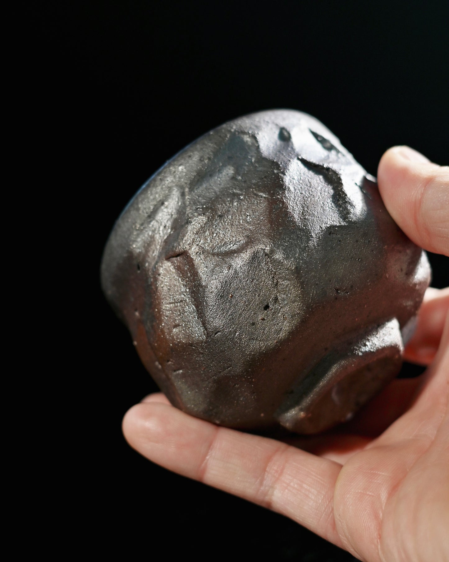 Naked wood firing process creating direct flame marks and ash traces on ceramic body