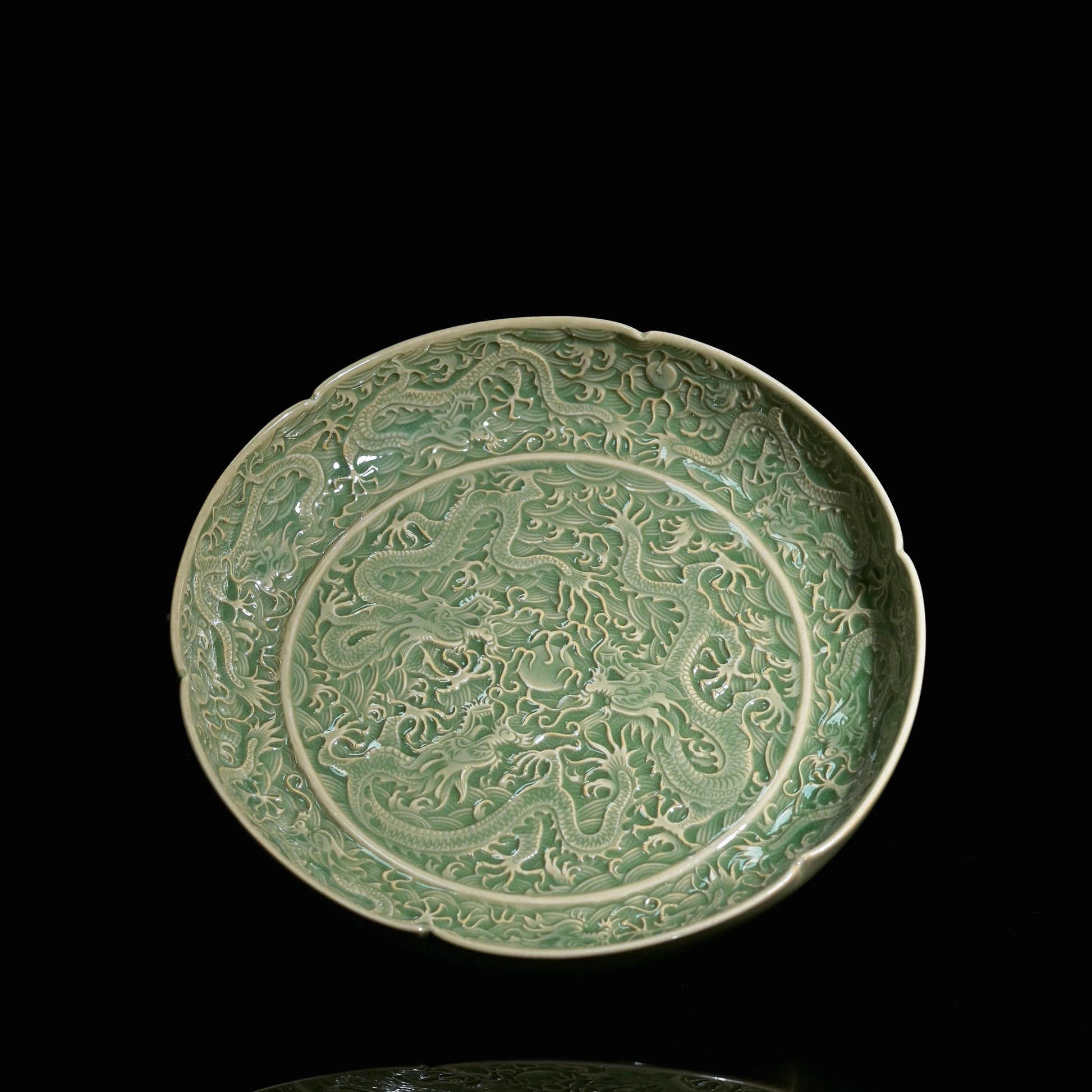 Yaozhou ware olive-green glazed plate with sharp carved nine dragons playing with a pearl motif