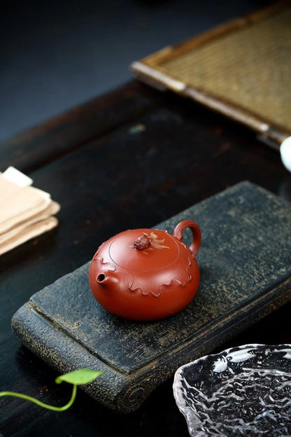Premium zhuni clay Xishi teapot with artisan hand-carved lotus patterns, distinctive flattened profile, and museum-quality pouring mechanics for discerning tea connoisseurs.