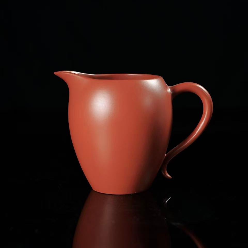 Yixing Zisha Da Hong Pao clay fairness cup showing warm crimson glaze and traditional shape