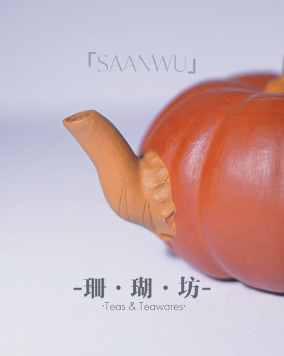 Detailed vine handle with sculpted leaves extending across the teapot surface