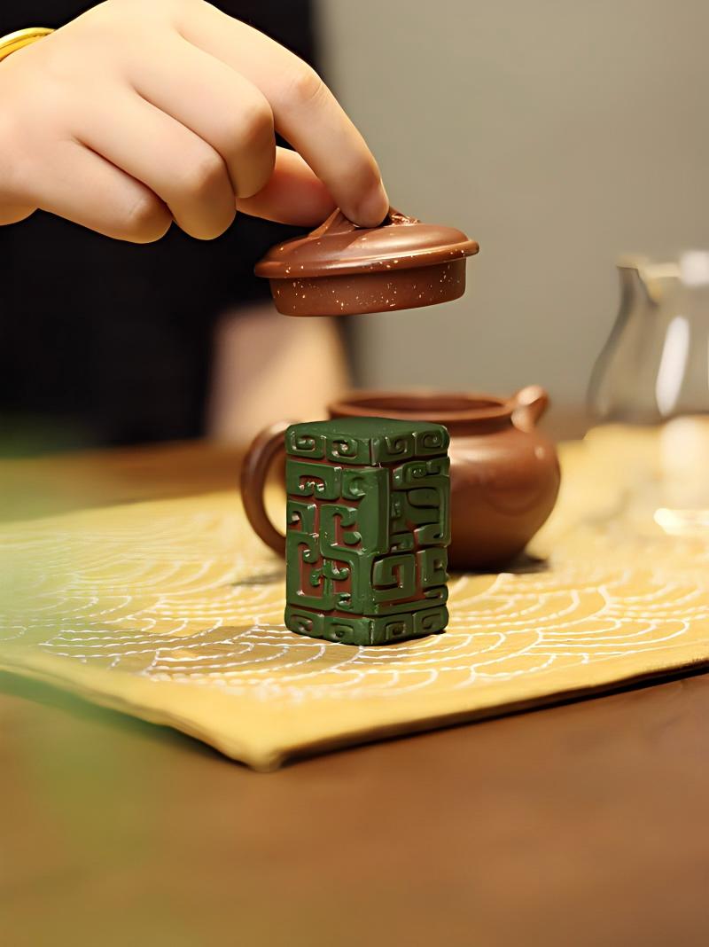 Carved Taotie tea pet stand with prominent rounded eyes and symmetrical horns from Shang bronze tradition