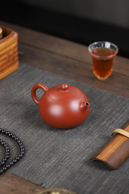 Xishi teapot - among Yixing's 10 classic shapes - in dahongpao clay, featuring flawless pouring precision and elegant feminine curves for pu'erh/oolong.