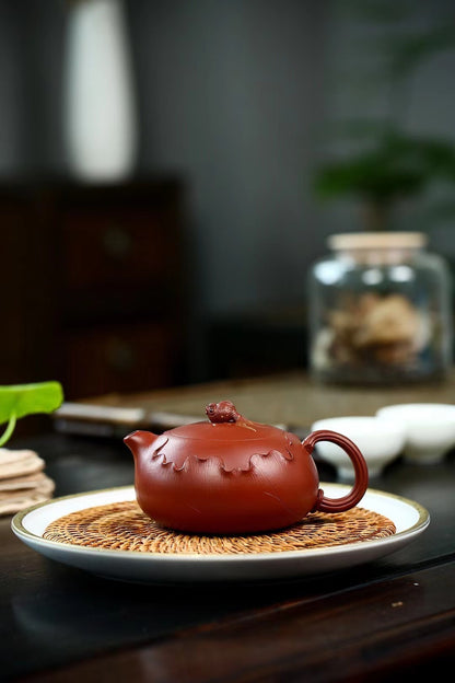 Saanwu Zhuni clay Xishi teapot with hand-engraved lotus decoration, flattened profile for comfort, and seamless water flow for ultimate tea service.