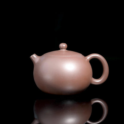 Pure Yixing zini clay Xishi teapot, fully handbuilt using Ming Dynasty techniques. The iron-rich purple clay naturally enhances tea aroma while the classic shape ensures perfect pouring balance.