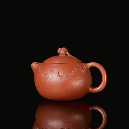 Yixing Zhuni Xishi teapot with rounded body, short spout, circular handle, and carved goldfish lid knob