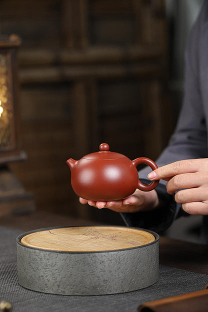 Artisan-crafted Yixing Xishi teapot from rare dahongpao mineral clay, unglazed and porous for optimal tea seasoning with pu'erh or oolong.